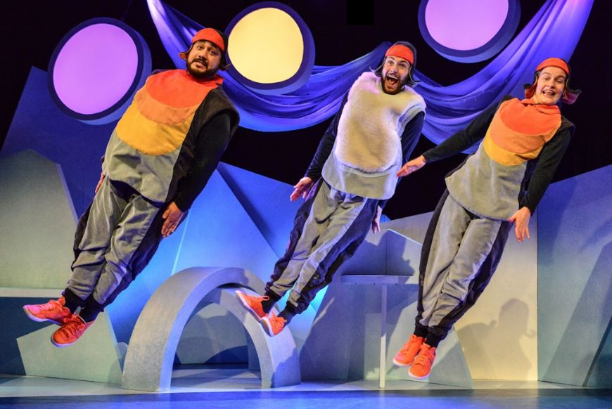 three people jumping in the air dressed as penguins
